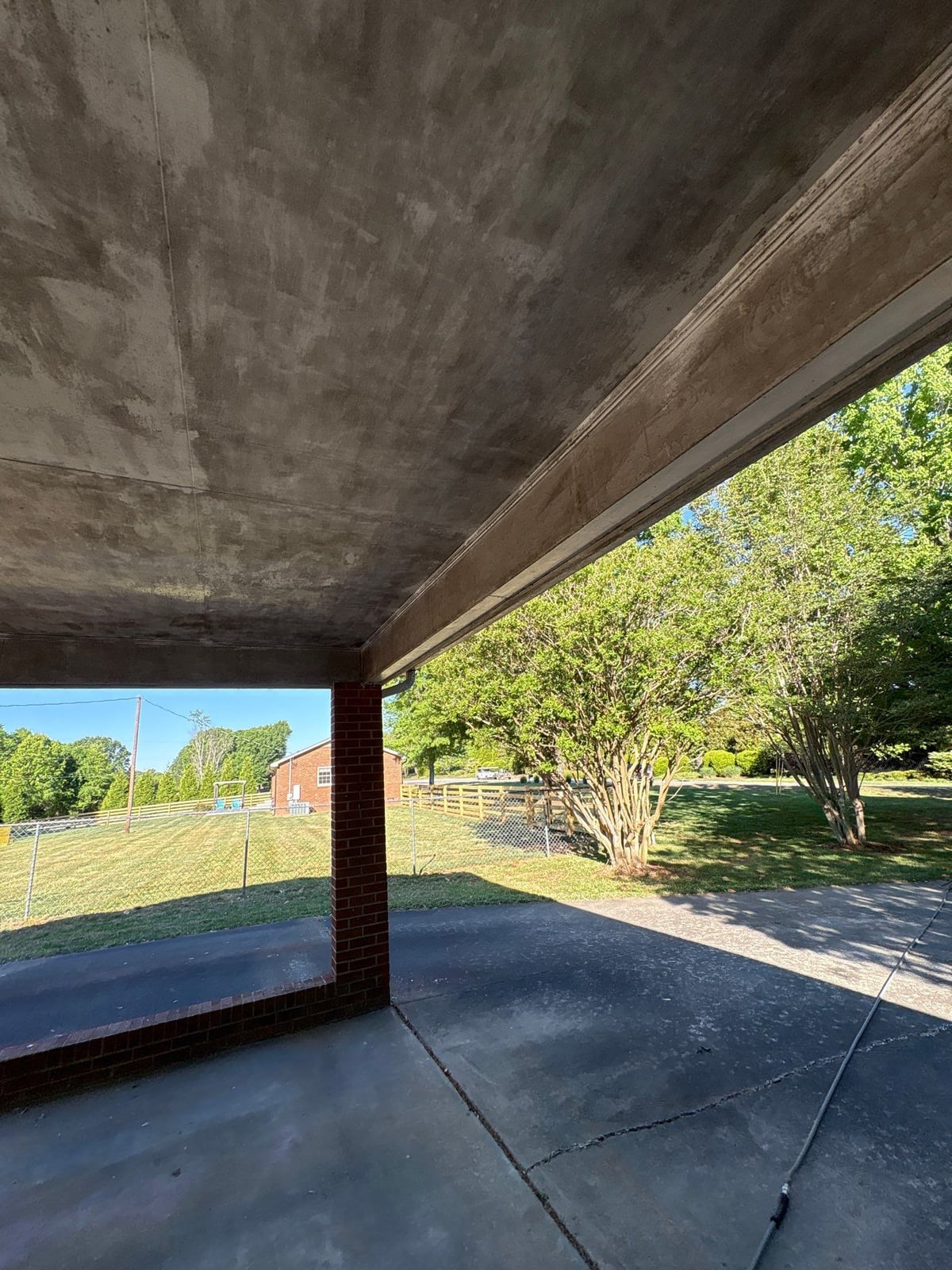 Exterior carport ceiling and concrete driveway pressure washing