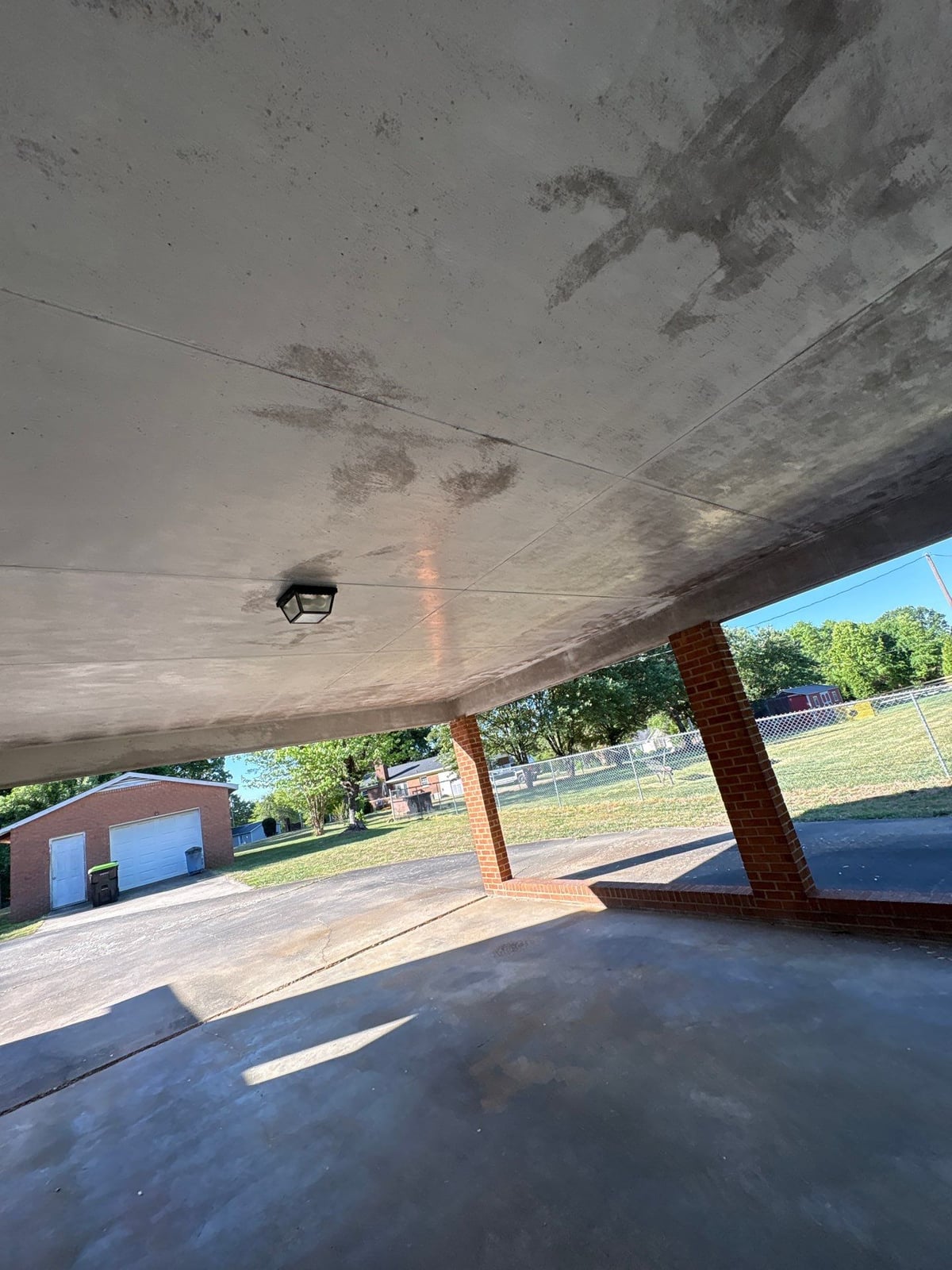 Exterior carport ceiling and concrete driveway pressure washing