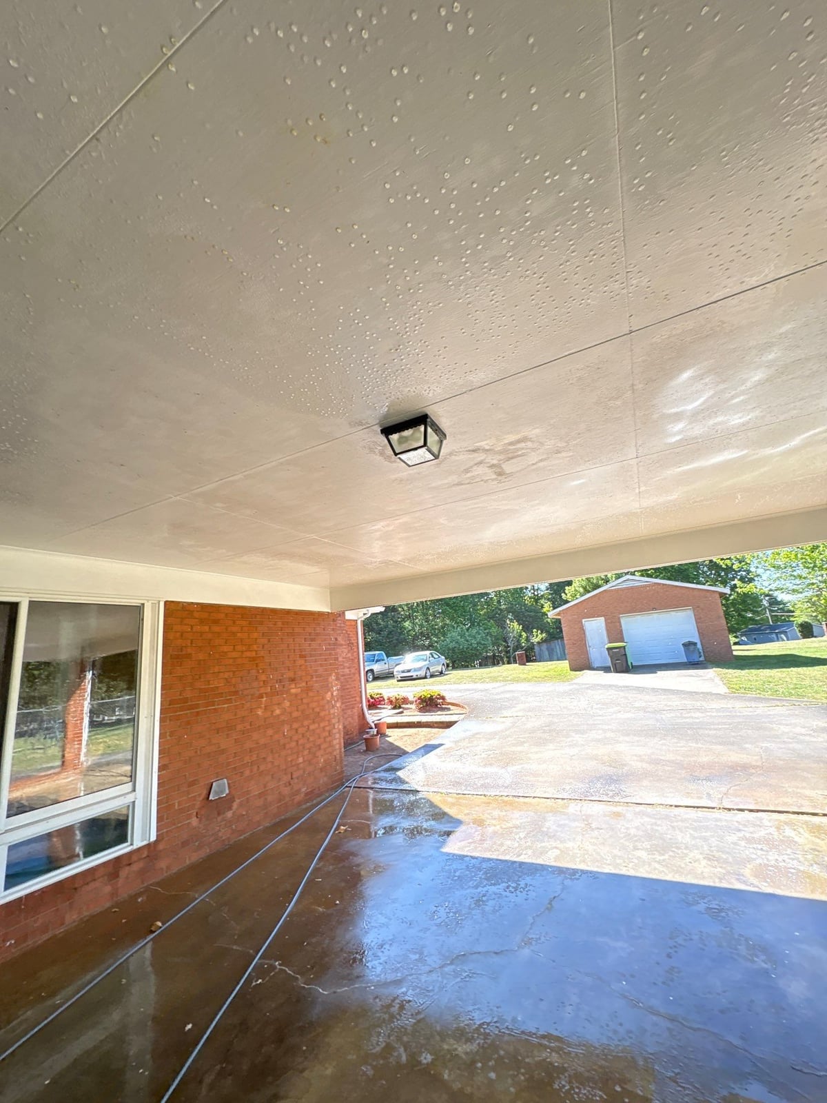 Exterior carport ceiling and concrete driveway pressure washing