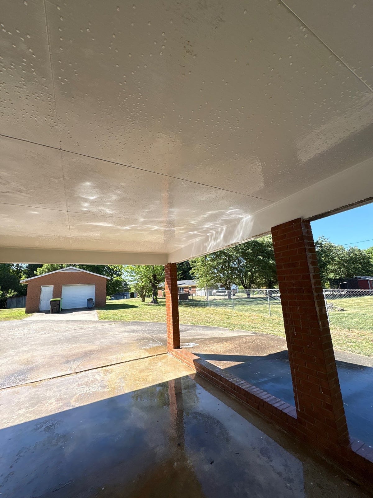 Exterior carport ceiling and concrete driveway pressure washing