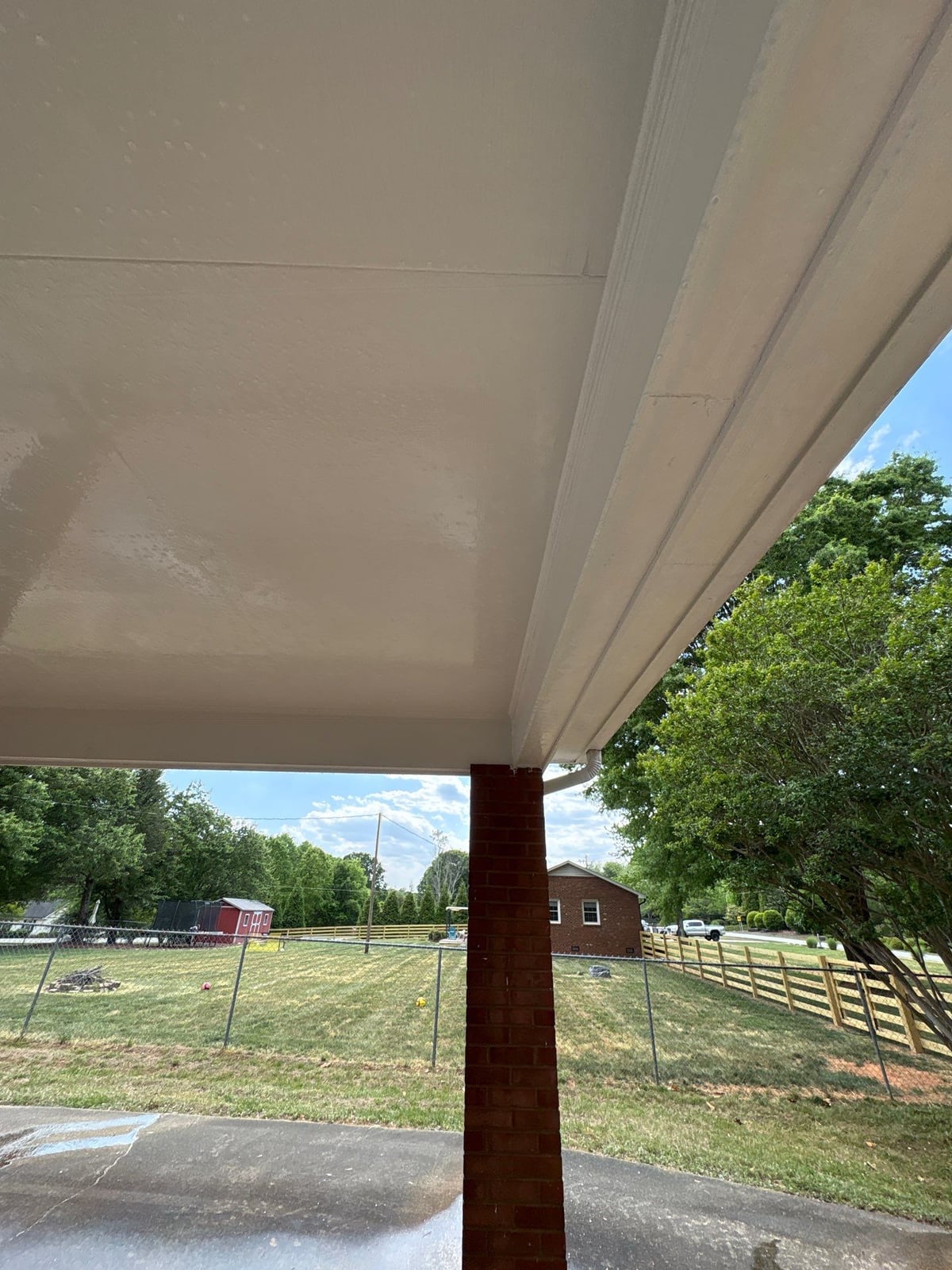 Exterior carport ceiling and concrete driveway pressure washing