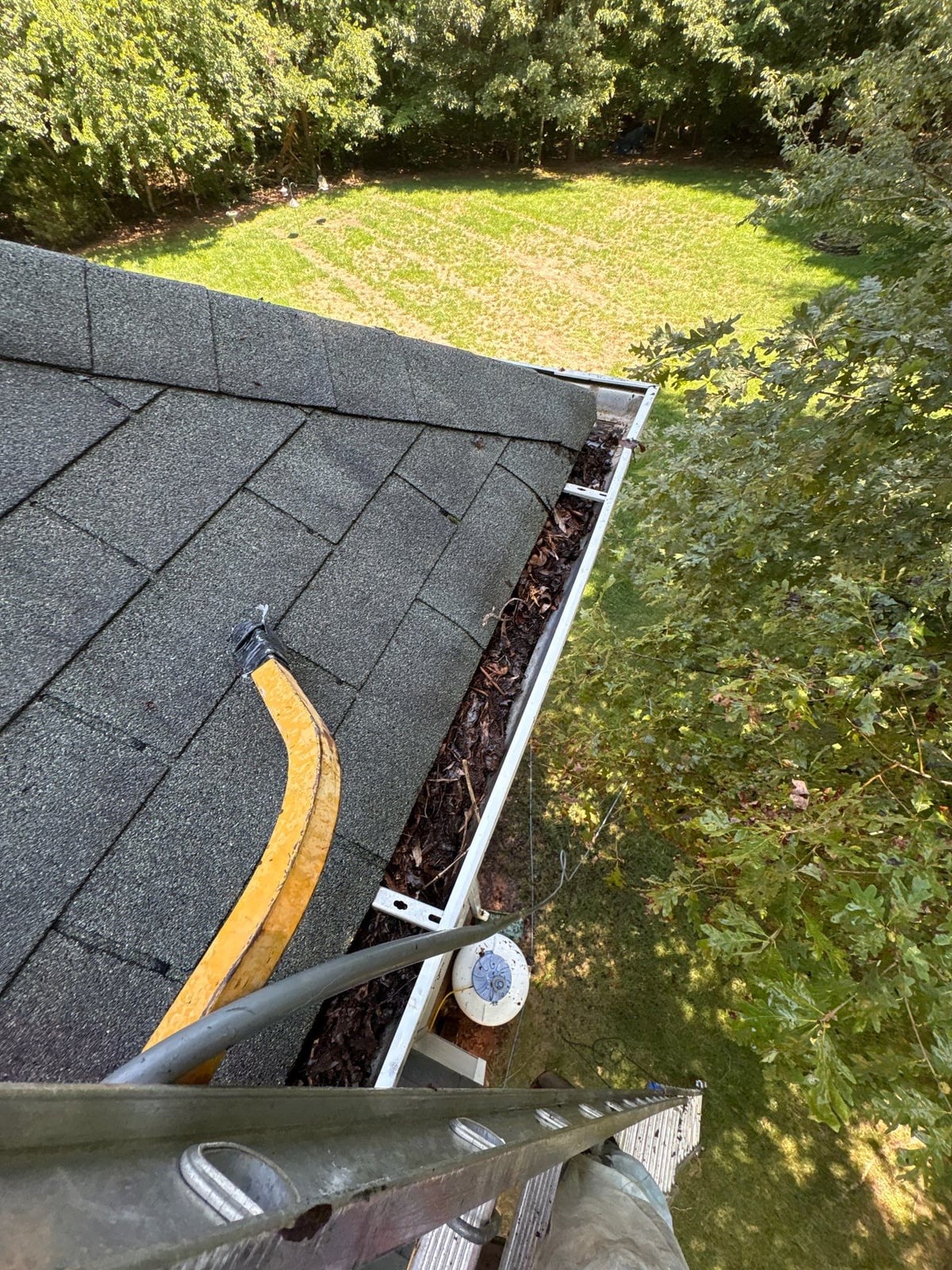 Clearing leaves and debris from house gutter system