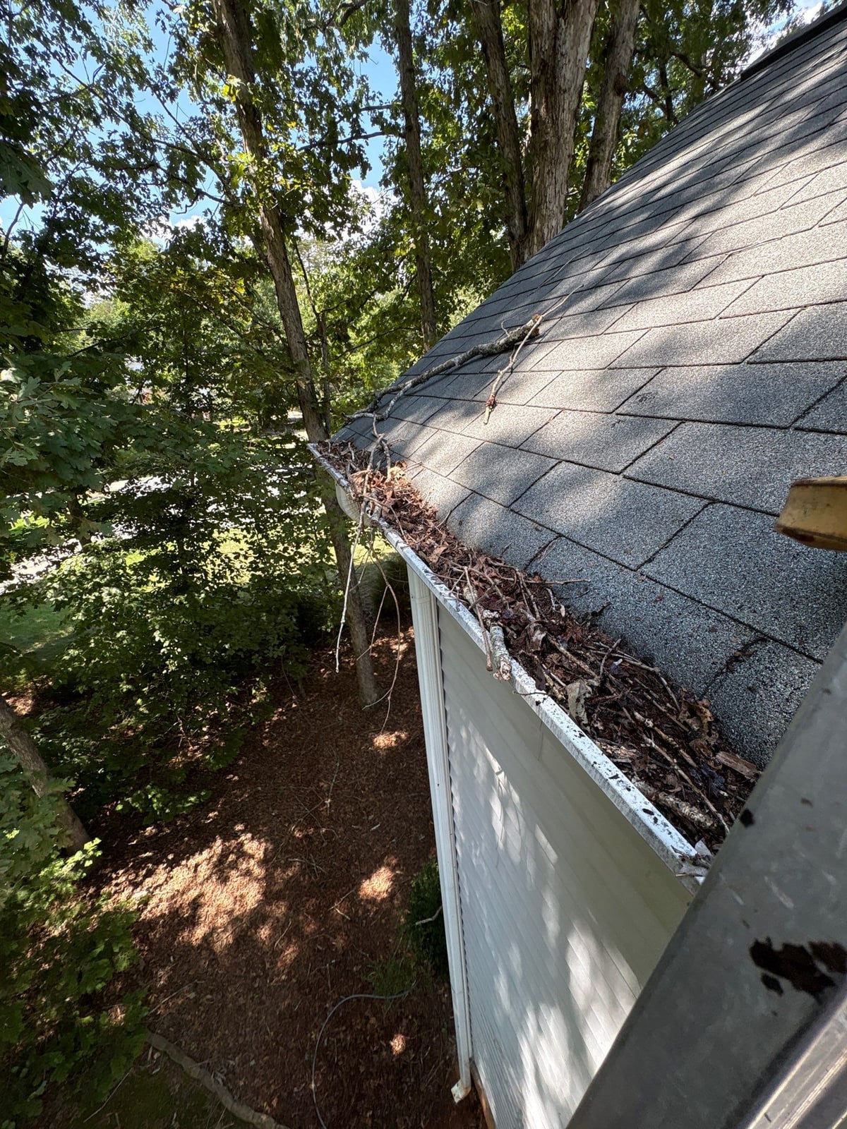 Clearing leaves and debris from house gutter system