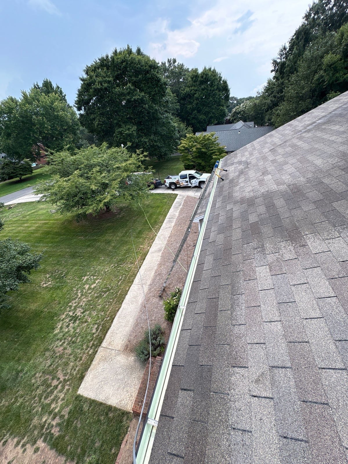Roofline gutter debris removal and downspout flow inspection