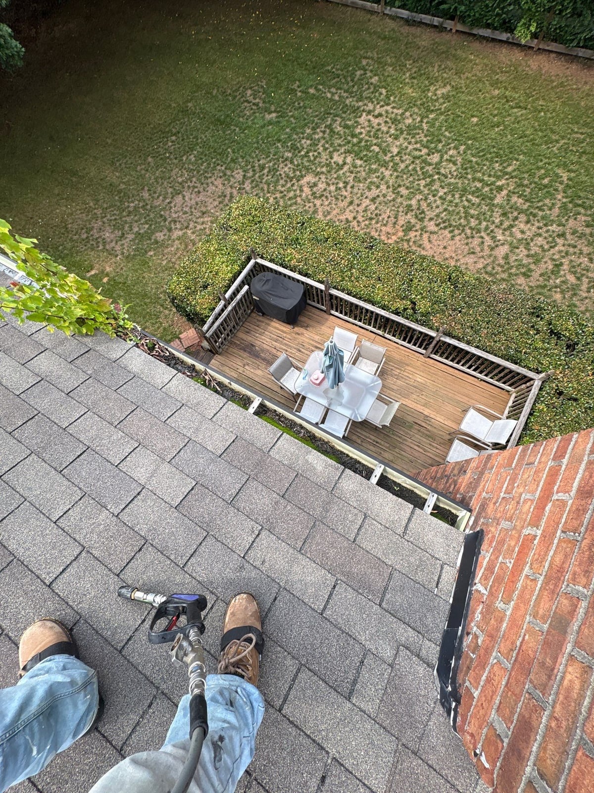 Roofline gutter debris removal and downspout flow inspection