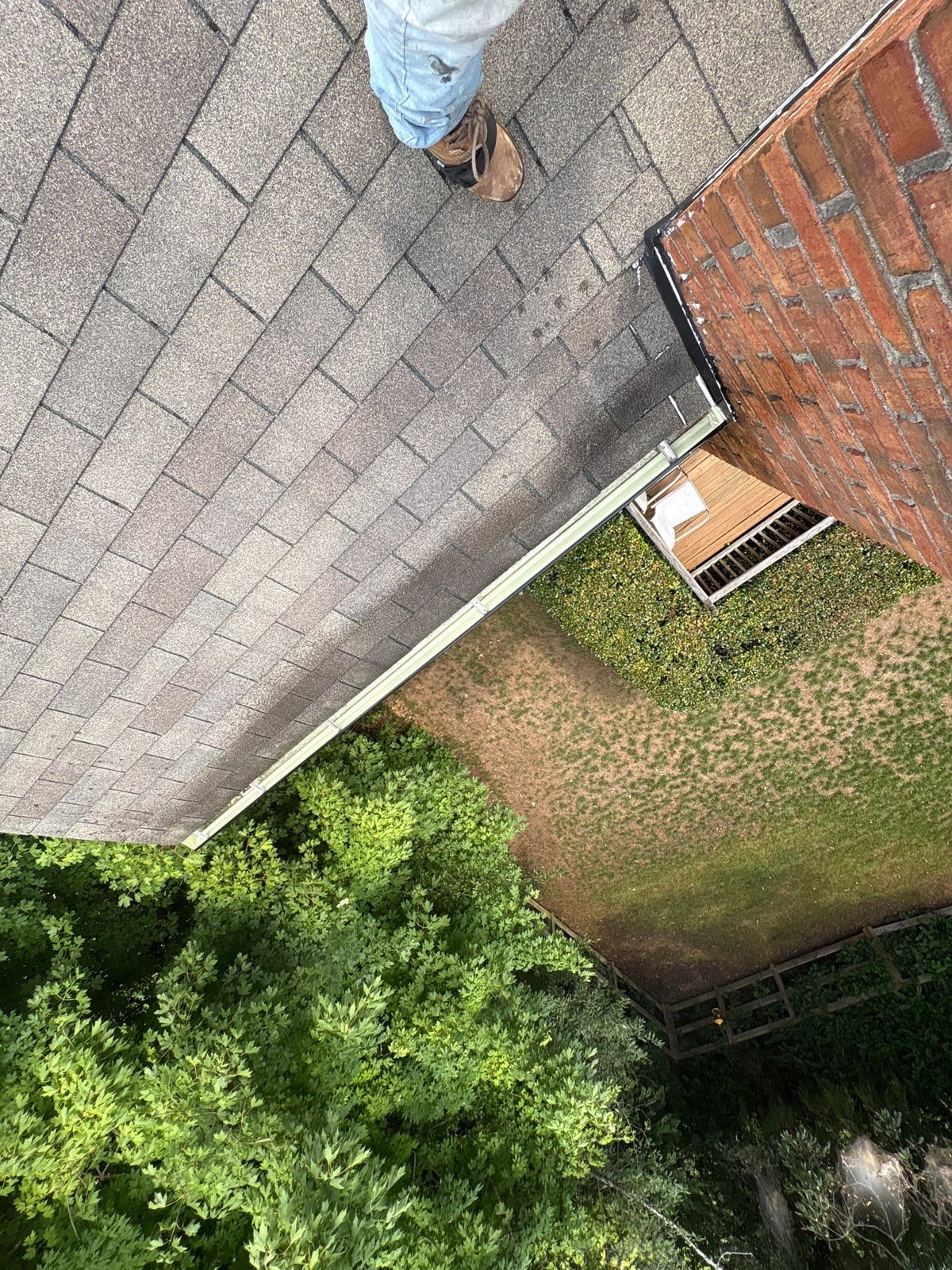 Roofline gutter debris removal and downspout flow inspection