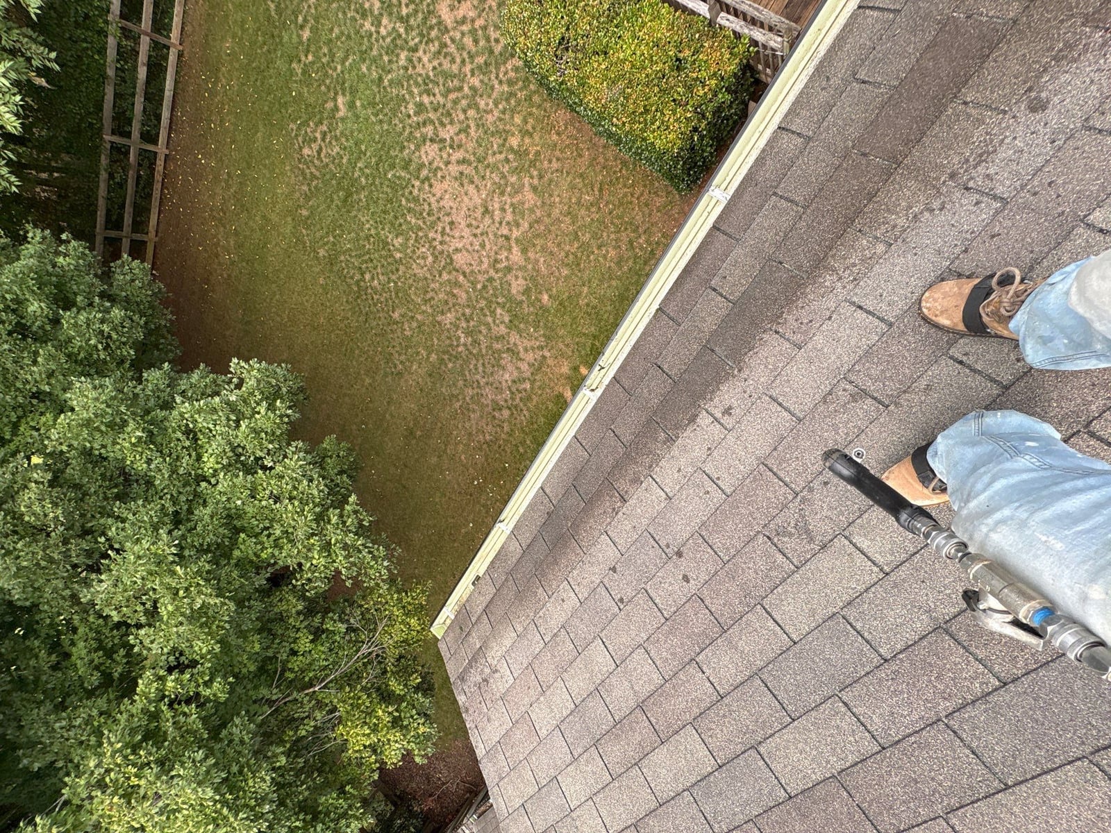 Roofline gutter debris removal and downspout flow inspection