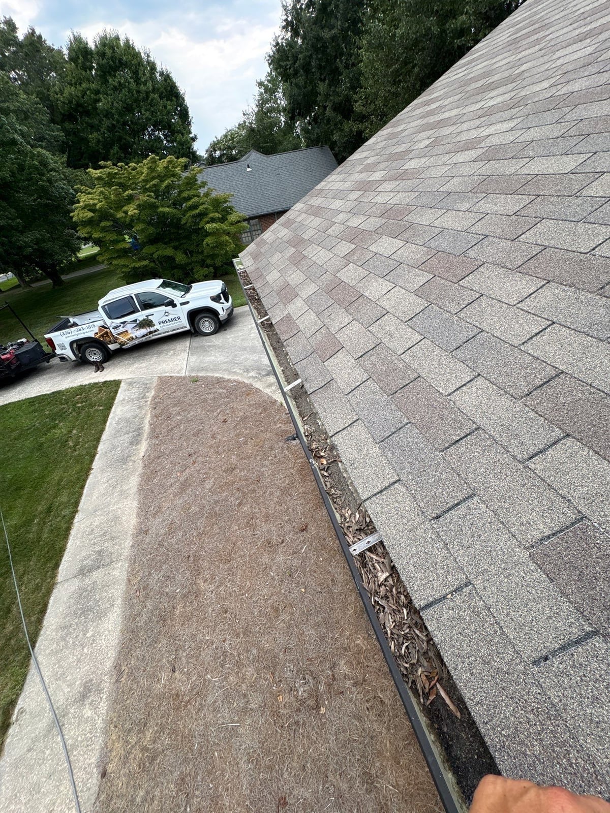 Roofline gutter debris removal and downspout flow inspection