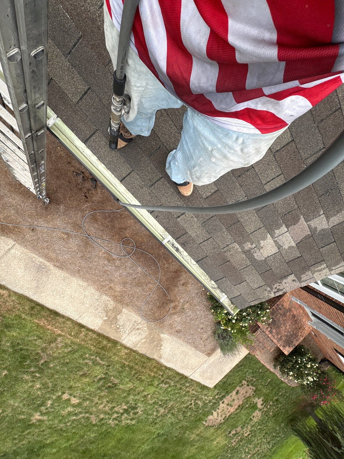 Roofline gutter debris removal and downspout flow inspection