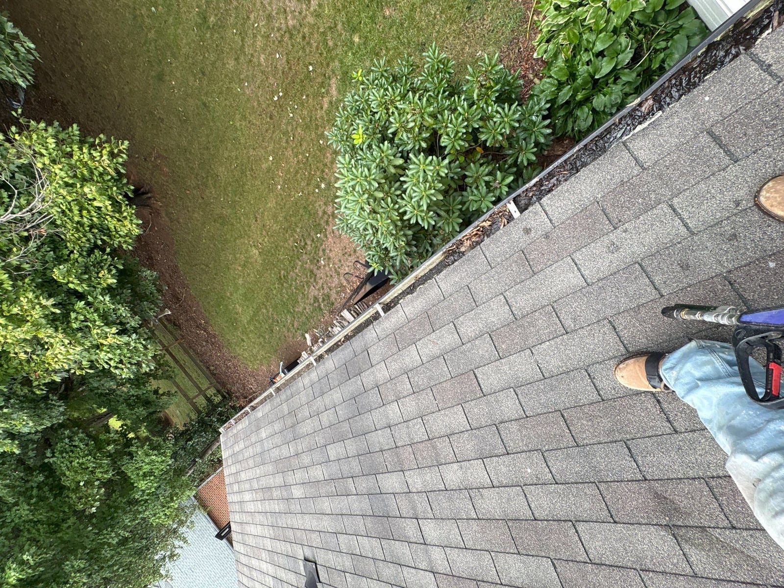 Roofline gutter debris removal and downspout flow inspection