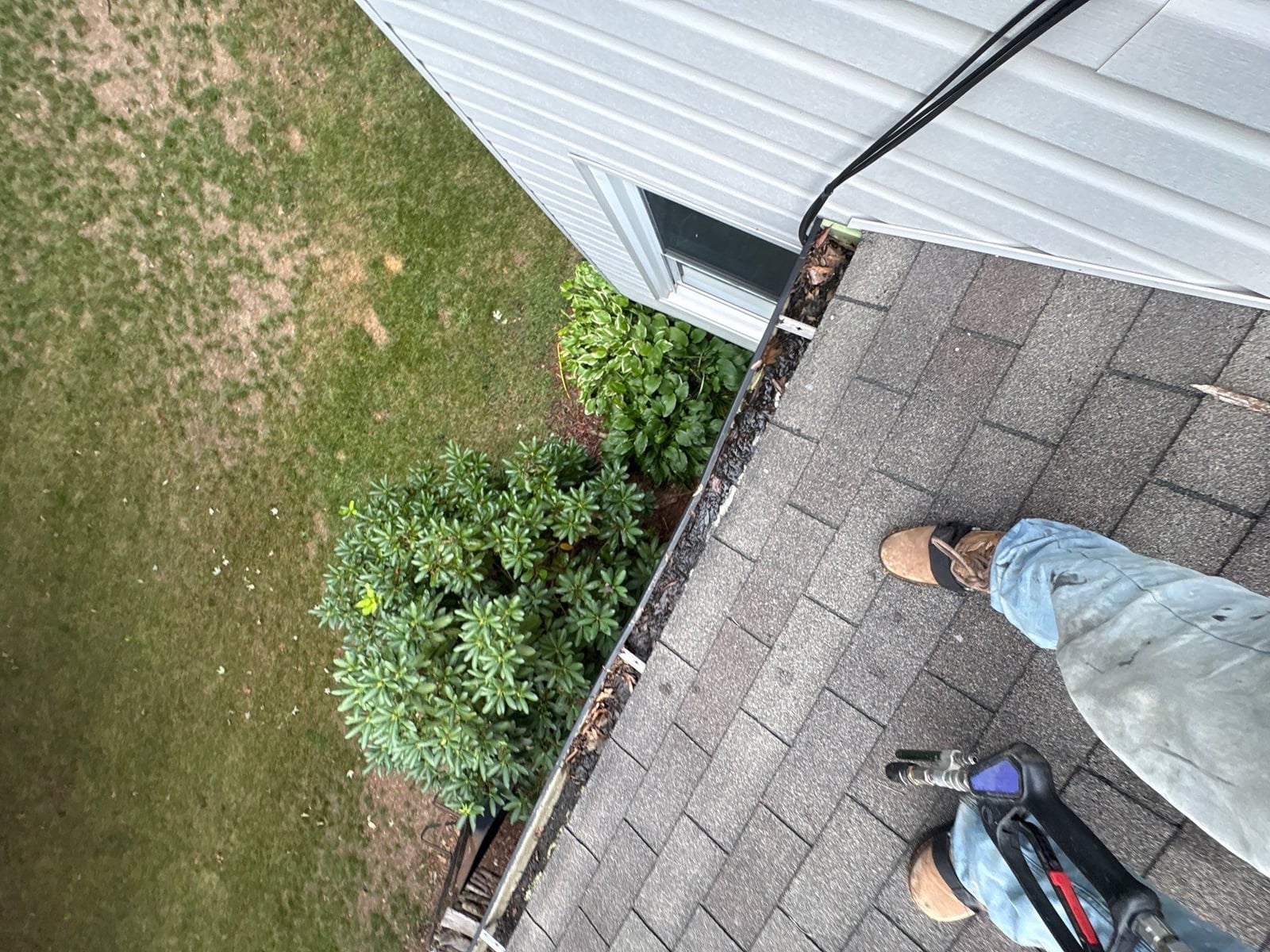 Roofline gutter debris removal and downspout flow inspection