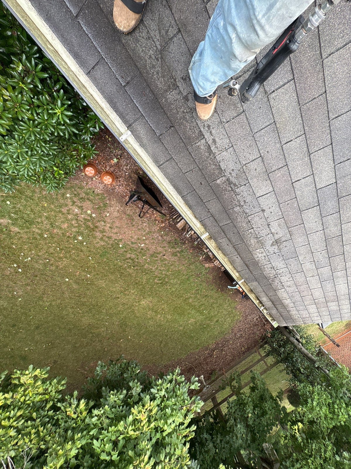 Roofline gutter debris removal and downspout flow inspection