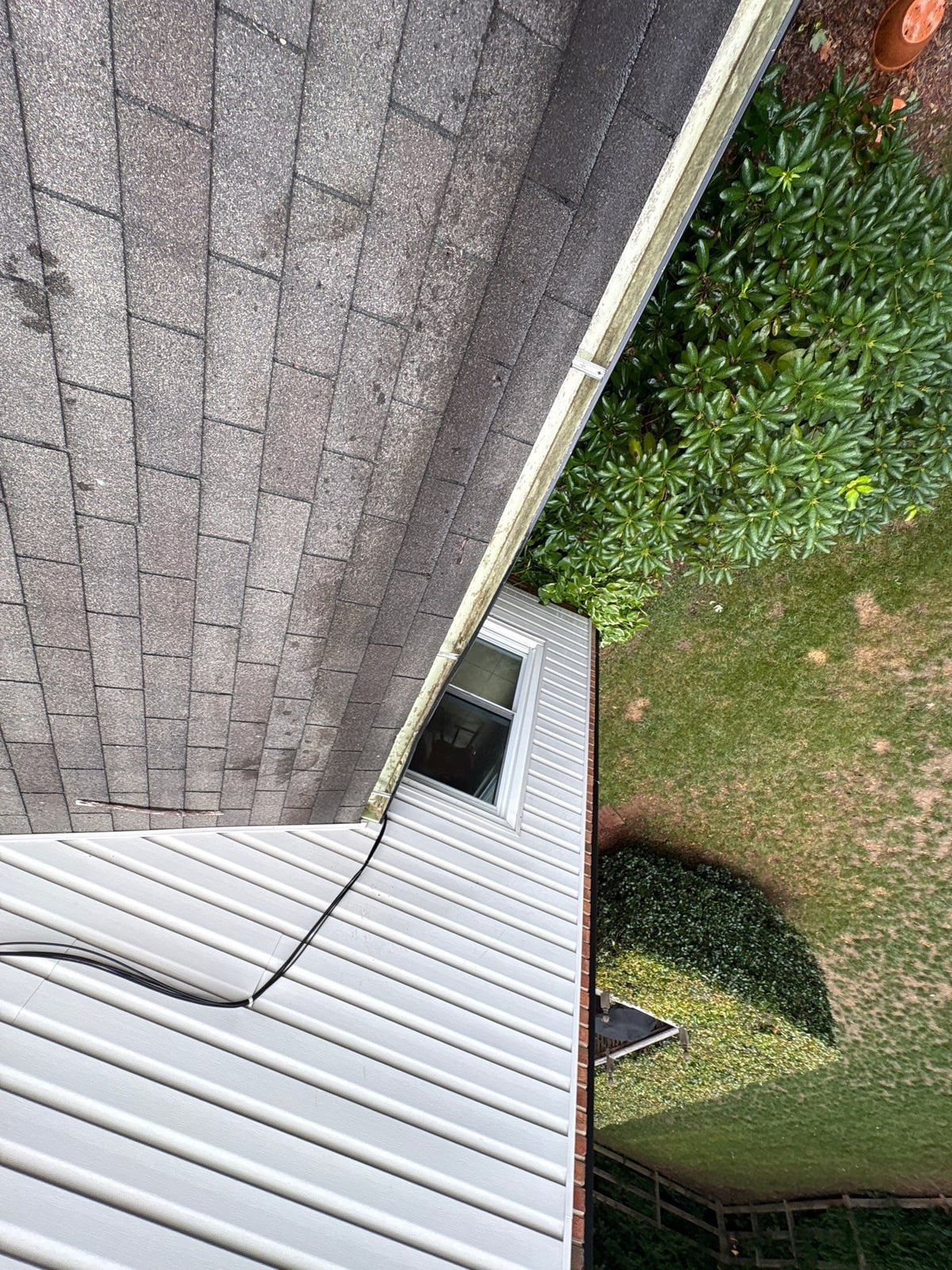 Roofline gutter debris removal and downspout flow inspection