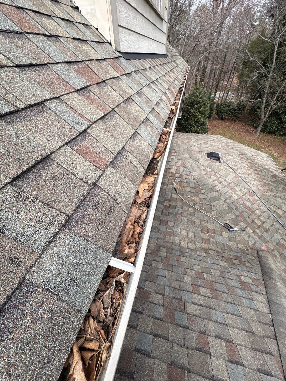 Exterior residential gutter cleaning and downspout debris removal